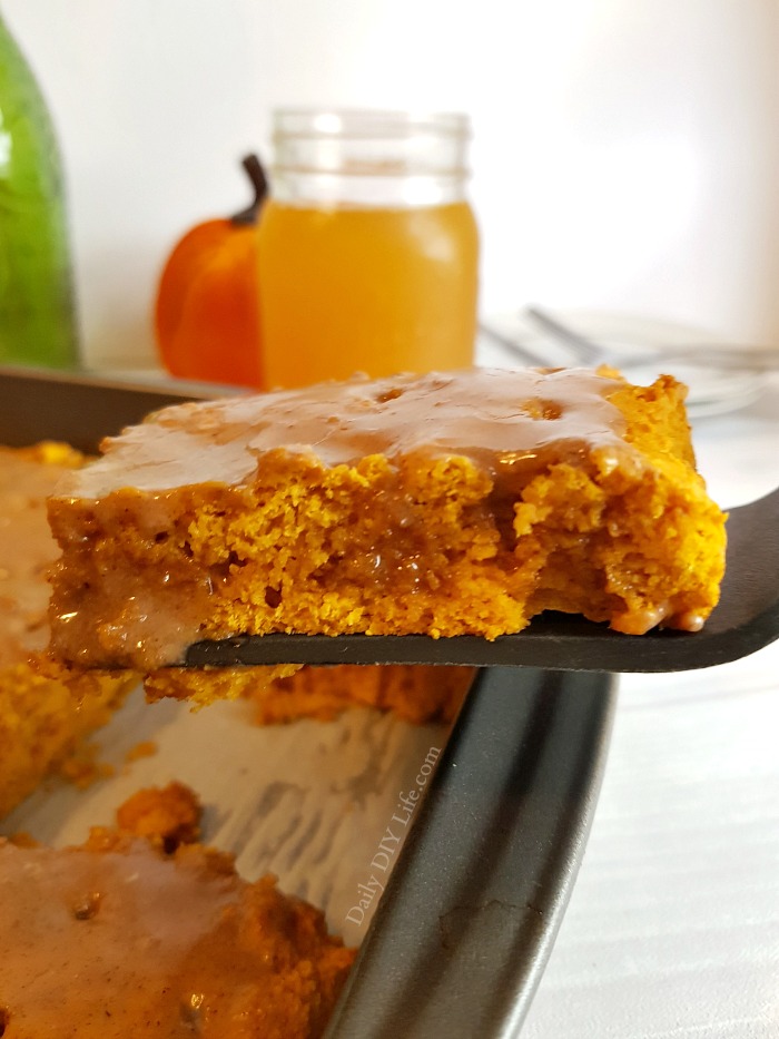 A slice of pumpkin dump cake with spiced glaze topping on top - 2 ingredient pumpkin dump cake