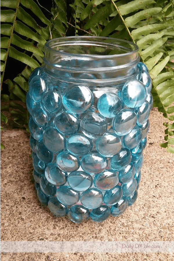 Whimsical DIY Mason Jar Luminaries will light up any outdoor space. If you are looking for a quick and easy craft to spruce up the patio, look no further. You may even have all of the materials already, and if you don't, your local dollar tree will have everything you need. #DIYGardenCrafts #DollarTreeCrafts #DollarStoreCrafts #SimpleDIY #OutdoorDecor #MasonJarCrafts #MasonJars 