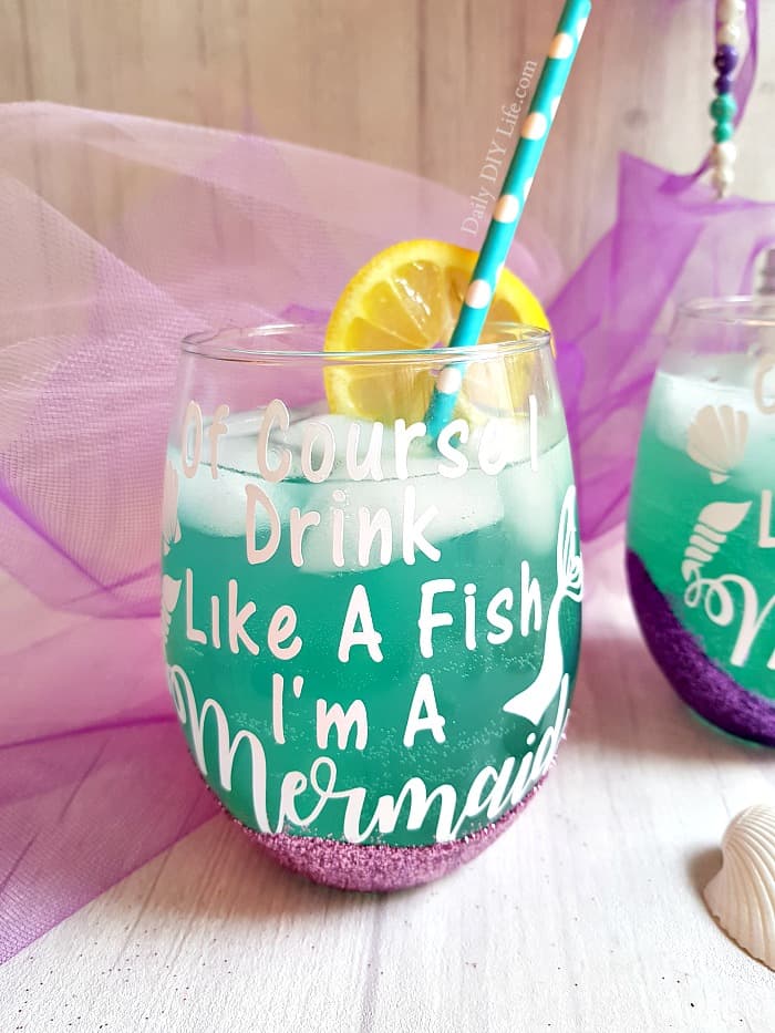 Create your own colorful and fun Glitter Wine Glasses right at home for a fraction of the cost of one in a specialty store. A fun easy DIY Cricut Project that will bring out your inner magical mermaid. Let's face it, everything is better with glitter and mermaid magic! #CricutMade #CraftAndCreateWithCricut #CricutDIY #GlitterGlasses #DIYWineGlasses #CustomGlasses #GlitterModPodge #ModPodge #BlingDIY