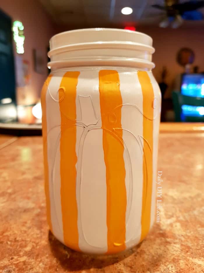 An adorable rustic plaid painted mason jar just in time for fall! Handpainted and colorful, this fun mason jar craft will look great where ever you put it. Use it as a vase for flowers, or in the center of your holiday table. The possibilities are endless. #CricutMade #Cricut #FallDIY #FallCrafts #MasonJar #MasonJarCrafts #CraftingWithMasonJars