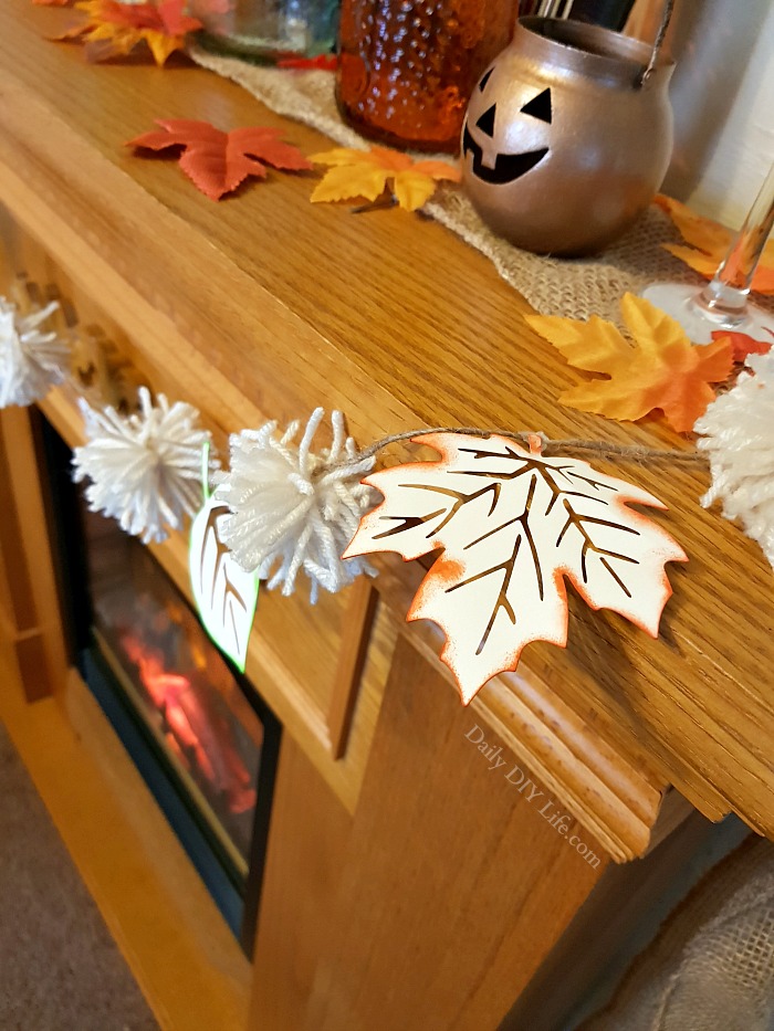 This quick and easy Fall banner can be made in minutes, and will add the perfect touch of Fall to your mantel or decorative shelves. Keep it neutral, or add lots of fun Fall colors. Either way, it will be a beautiful edition to any decor. #CraftandCreateWithCricut #CricutMade #CricutCrafts #FallDecor #PaperCrafts #PomPomCrafts