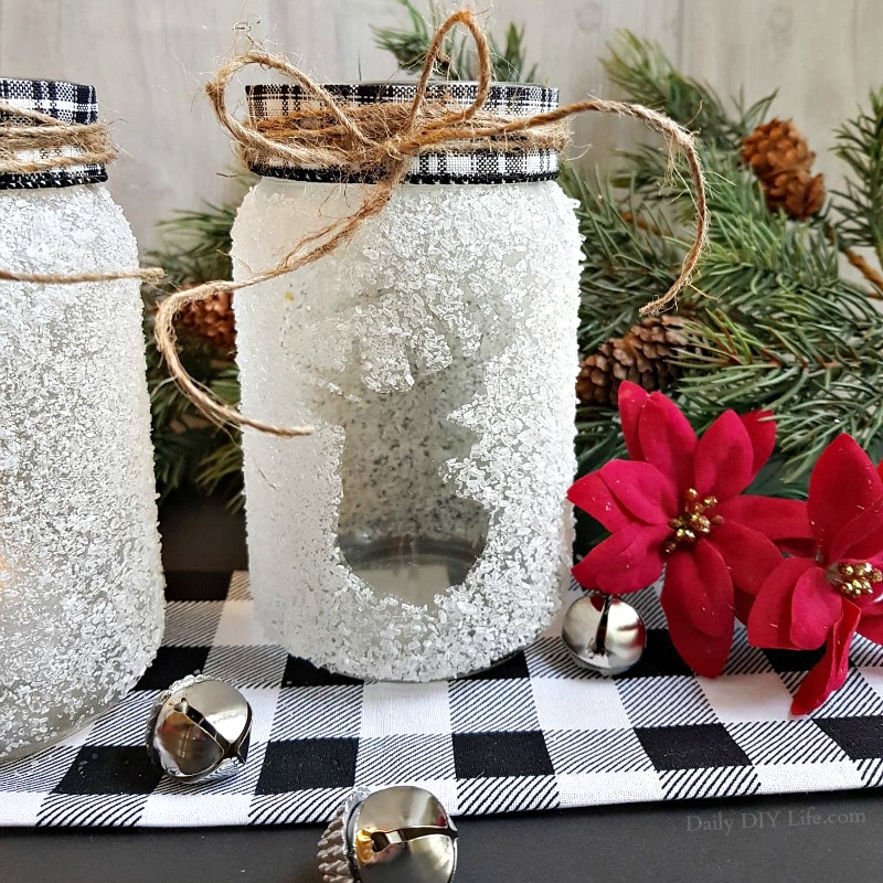 Beautifully decorated DIY mason jar Christmas crafts with festive holiday ornaments and fairy lights.