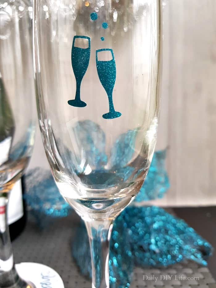 Add a little glitz and glam to your New Years Eve celebration with these easy DIY Paper Champagne Glass Tags. A little extra sparkle is always welcome on New Years Eve. These fun tags are quick to make and can be completely customized using your Cricut or Silhouette cutting machine. #Sponsored #Styletechcraft #StyleTech #StyleTechCraftVinyl #Cricut #CricutMade #CricutProjects #VinylProjects #GlitterVinyl #UltraMetallic #UltraGlitter #NYECrafts #NewYearsEve