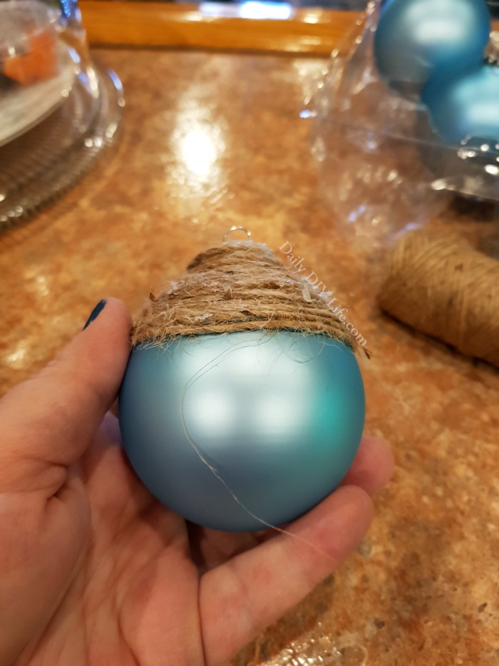 Beautiful Coastal Christmas Ornaments in a lovely sea blue with rustic natural twine are just the right touch to bring a bit of the beach to your holiday tree this year. Using simple supplies from the Dollar Tree, you can have these rustic elegant Christmas bulbs made in no time. If you are a lover of all things coastal, or beach decor at the holidays, you are going to love making these. #DollarTreeChristmas #CoastalChristmas #ChristmasOrnamentsDIY #DIYChristmas #DIYCoastalChristmas #CoastalChristmasCrafts #ChristmasDIYOrnaments #SeaBlueDecor #DIYChristmasCraft