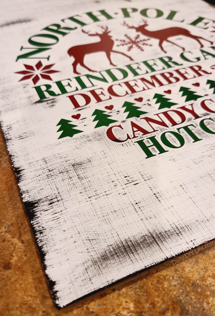 Whimsical oversized gift tags from the dollar tree are transformed into a beautiful Christmas Door Hanger with a little paint and shimmering luster vinyl. This is an easy holiday craft that can be made using your Cricut cutting machine and StyleTech Craft luster vinyl. #Sponsored #StyleTechCraft #StyleTech #LusterVinyl #CricutMade #CricutChristmas #VinylChristmasCrafts #ChristmasDollarTree