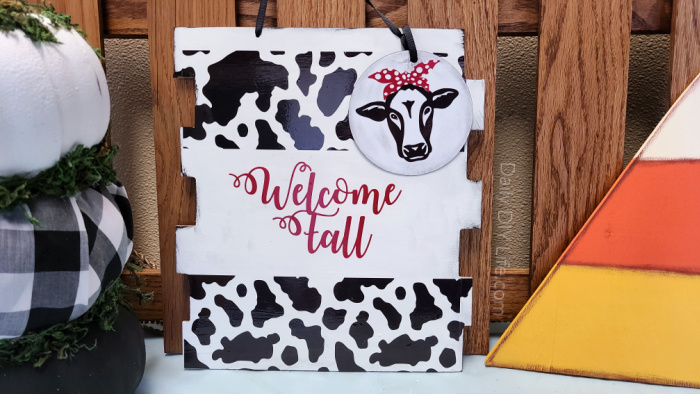 If you are looking for a fun, unique Fall Door Hanger, this adorable cow print welcome sign just may do the trick. With supplies from StyleTech Craft and the dollar tree, this cute cow print welcome sign can be put together in no time. #sponsored #StyleTechCraft #Cricutmade #cricut #MetalizedVinyl #cowprint #FallDIY #DollarTreeCrafts #FallDecor