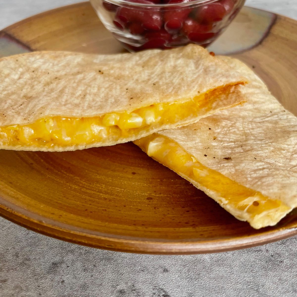 air-fryer-quesadilla-on-ceramic-plate-with-beans