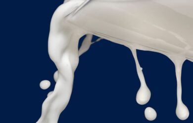 milk pour from glass on blue background