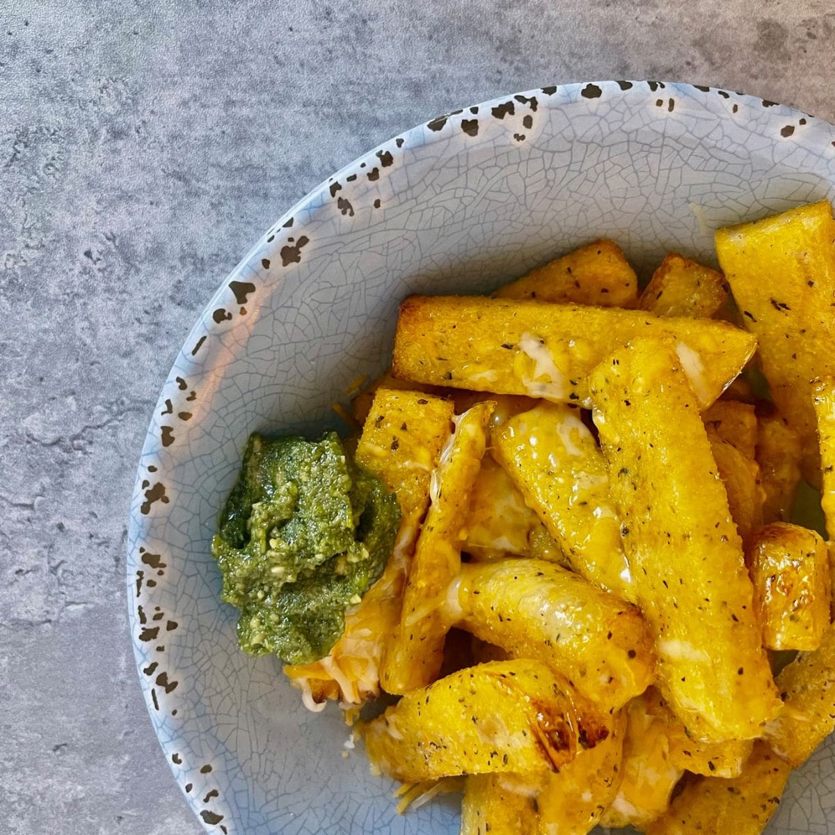 truffle fries in blue bowl with side of pesto