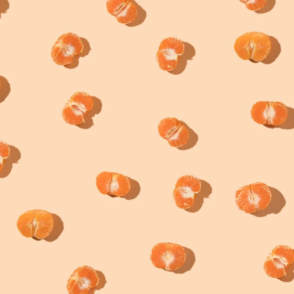 peeled oranges on light orange background
