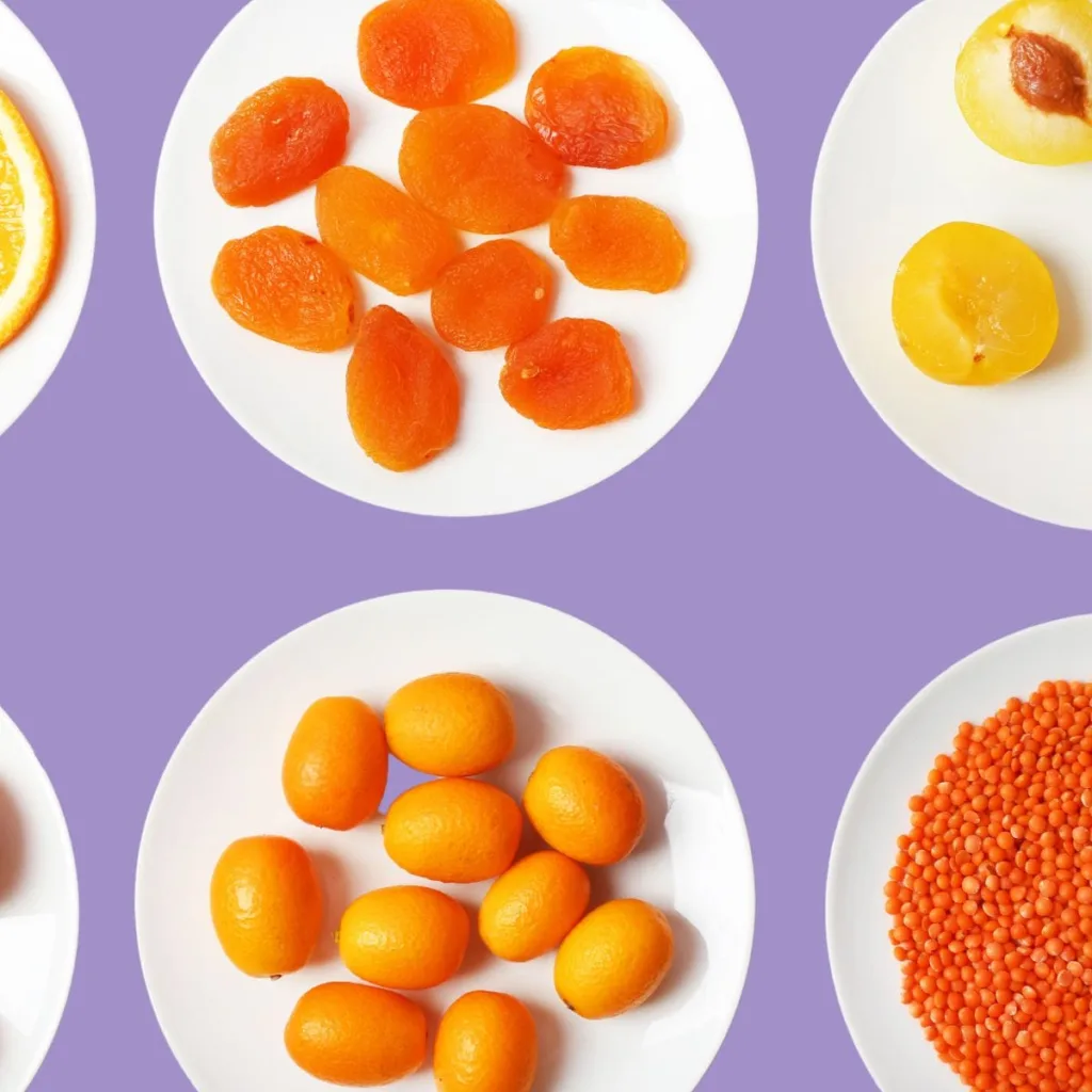 plates of orange foods on violet background