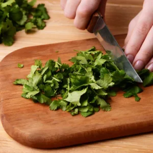 chopping cilantro on wooden board
