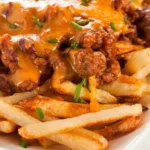 close up of fries with leftover chili on top