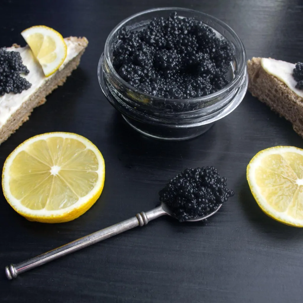 bowl of black caviar with sliced lemon