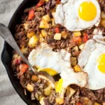 canned beef hash with eggs in skillet