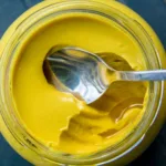 close up of dijon mustard with spoon